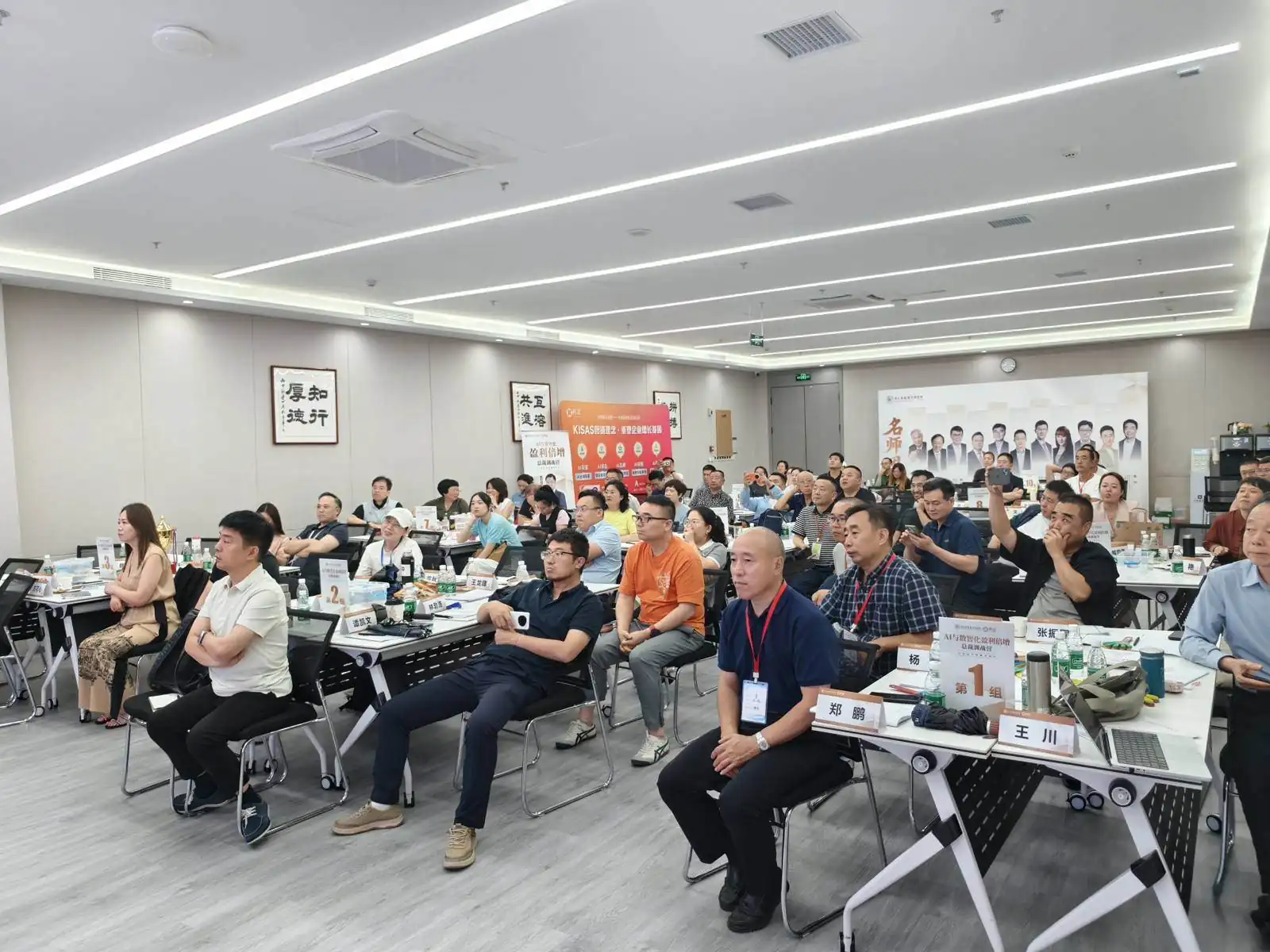 企业内训课堂：学员围桌而坐，前方投影展示课程内容