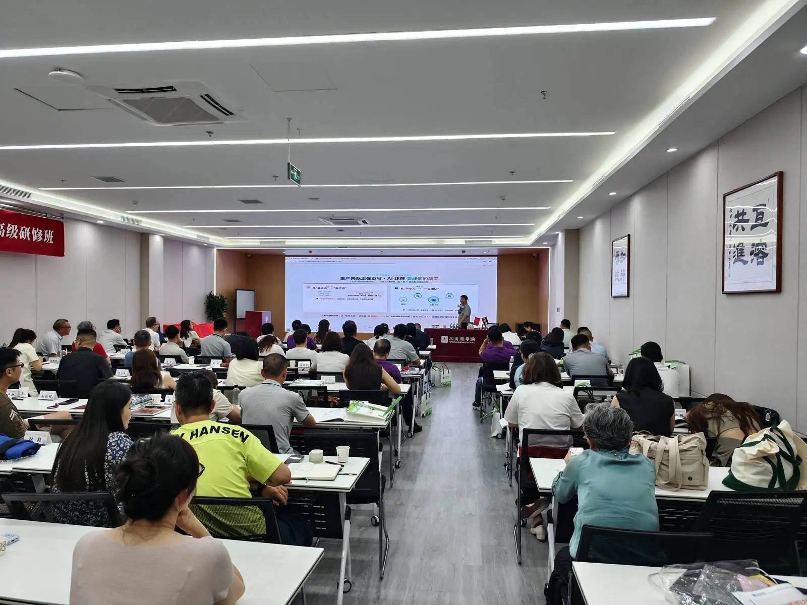 课堂全景：长桌分组、投影幕布与讲师台